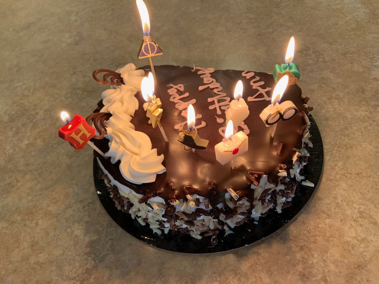 a chocolate-vanilla birthday cake with Harry Potter candles lit