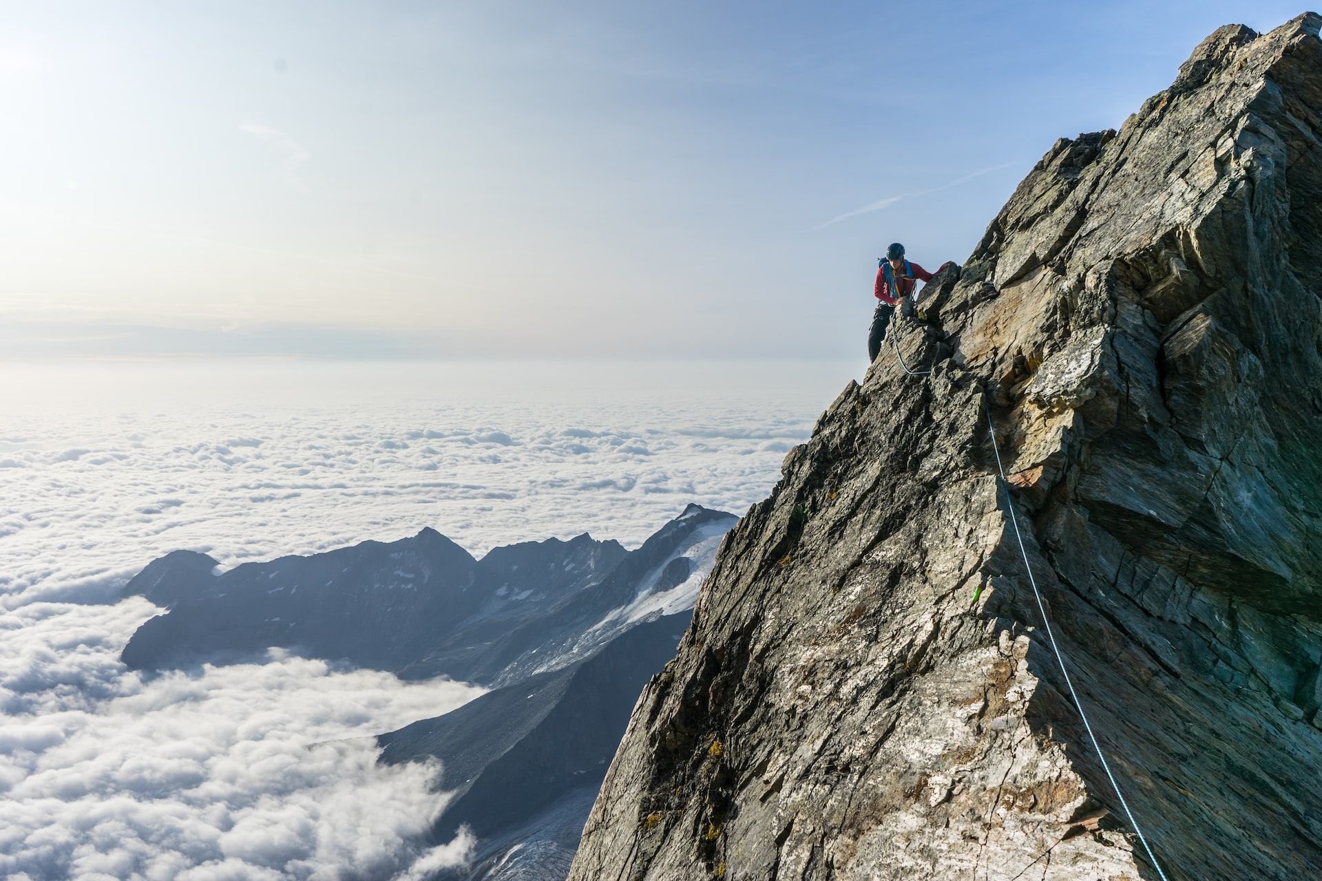 cliff climbing on a rock face above a sea of clouds