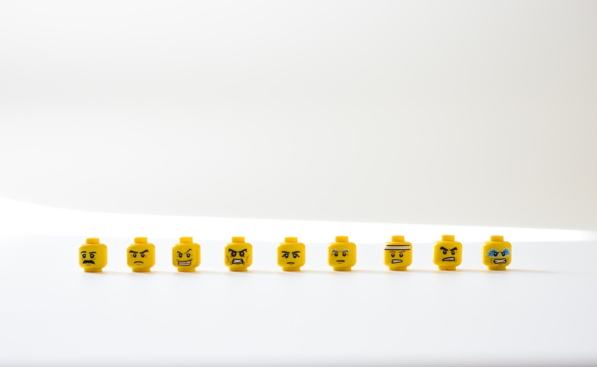 Nine Lego figurine heads with different facial expressions