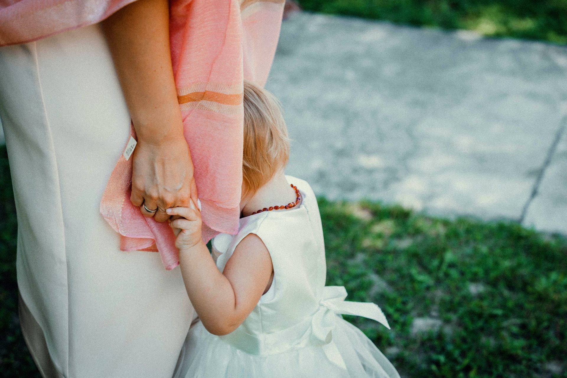 child hiding between her mother's legs