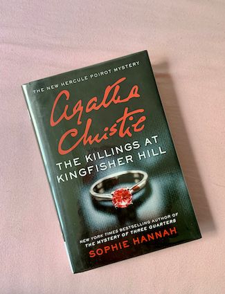 hardvoer copy of The Killings at Kingfisher Hill, a Hercule Poirot novel, by Sophie Hannah featuring a silver ring with a bloodied diamond stone