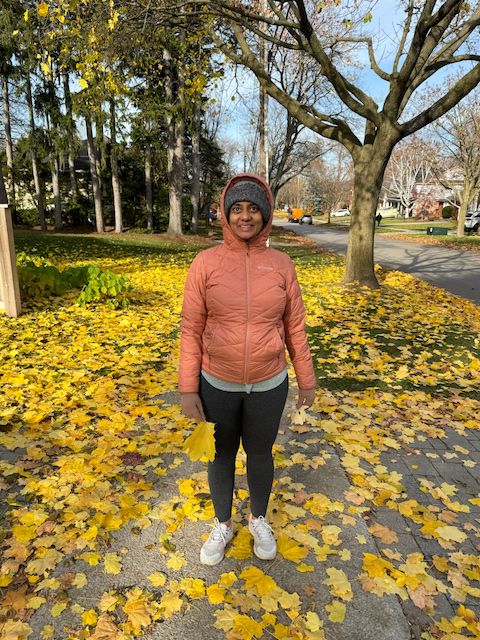 Me standing on a sidewalk full of fallen yellow leaves