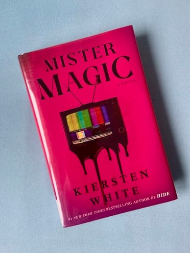 Hardback copy of Mister Magic by Kiersten White featuring an old television screen against a pink background