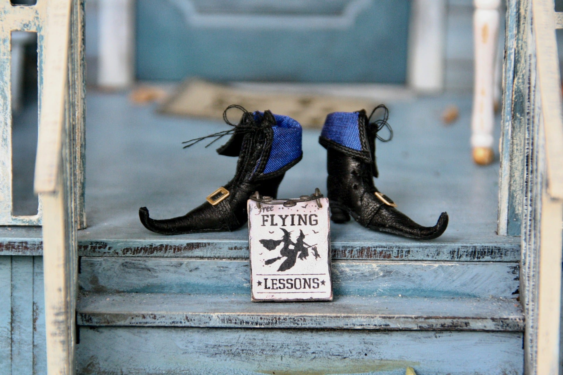 pair of black boots atop a flight of blue steps with a poster for Flying Lessons in front