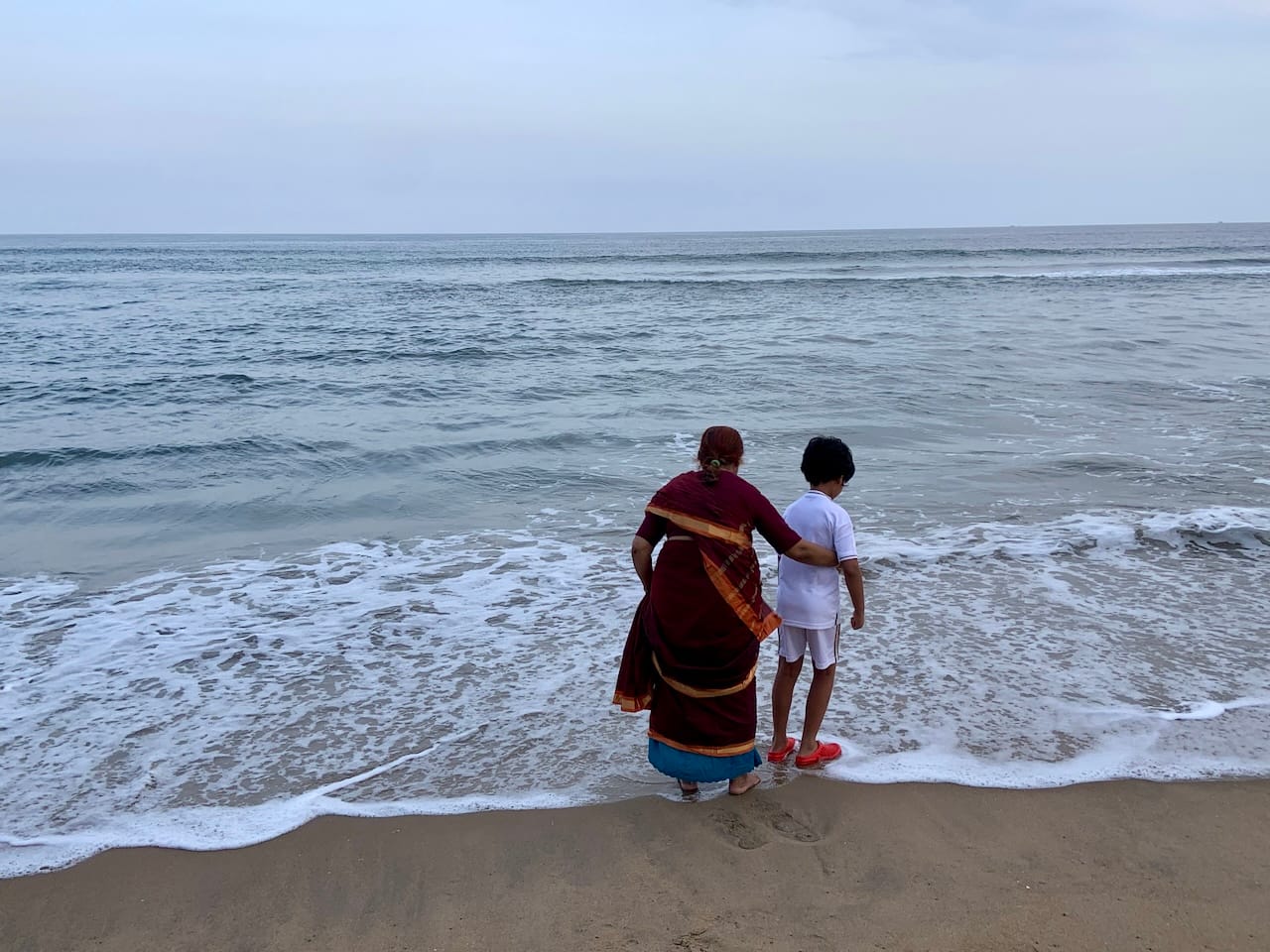 my mom and little D at the seashore getting wet in the water