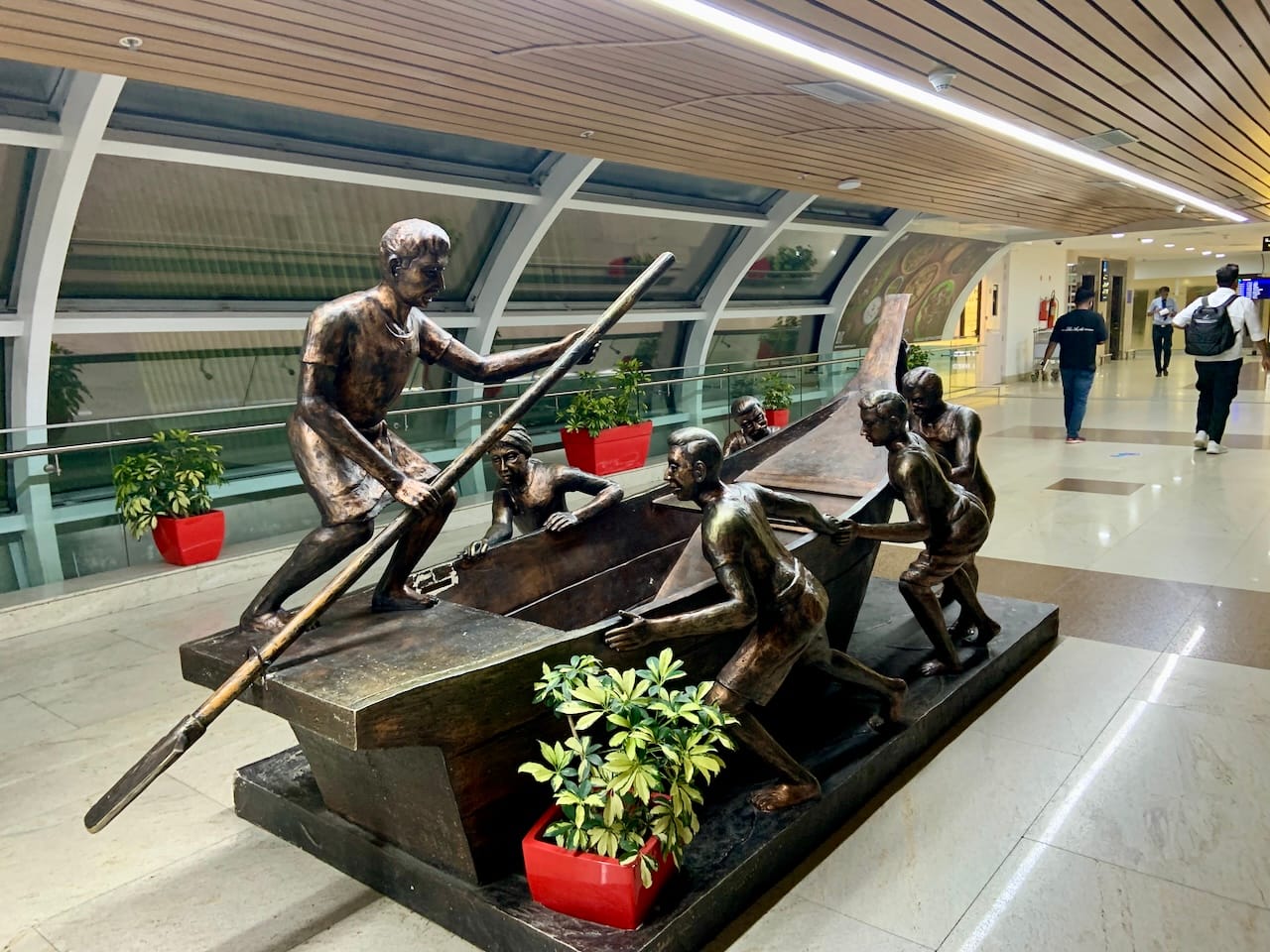 a sculpture of fishermen pushing a boat into the waters