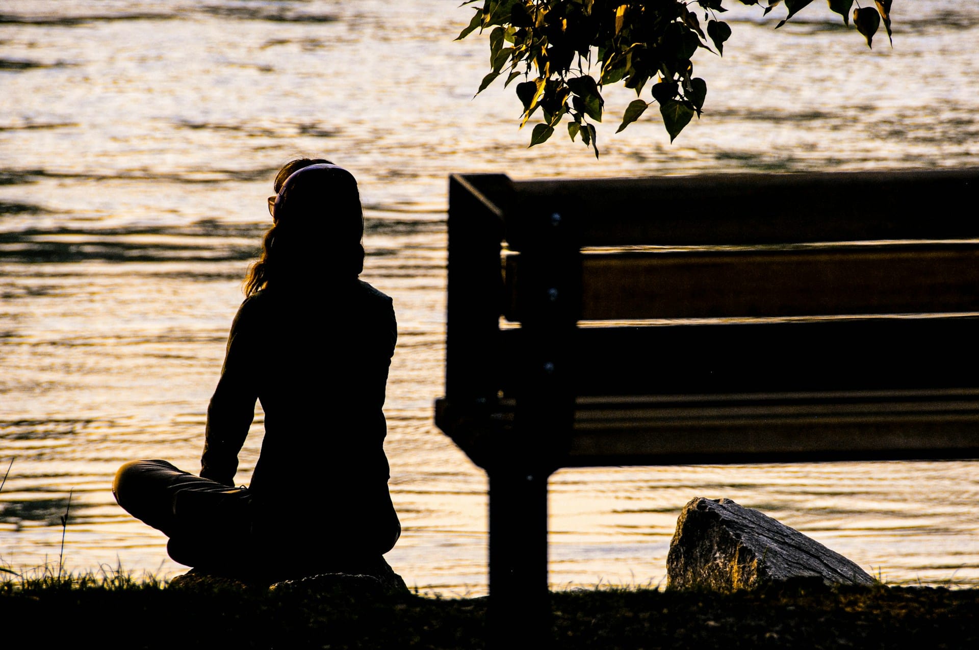 woman sitting by a waterfront in solitude