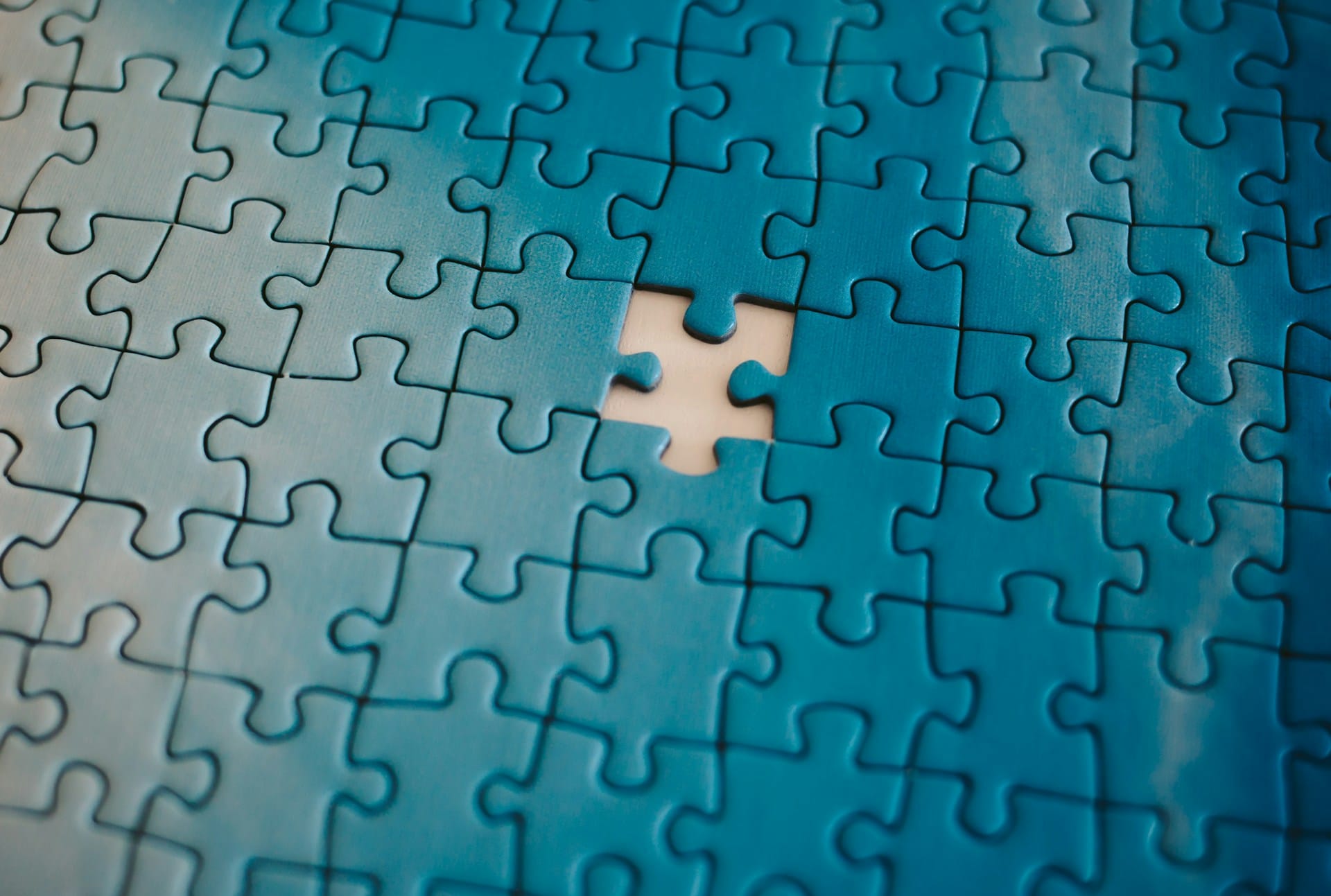 close-up image of a jigsaw puzzle with a single missing piece in the centre