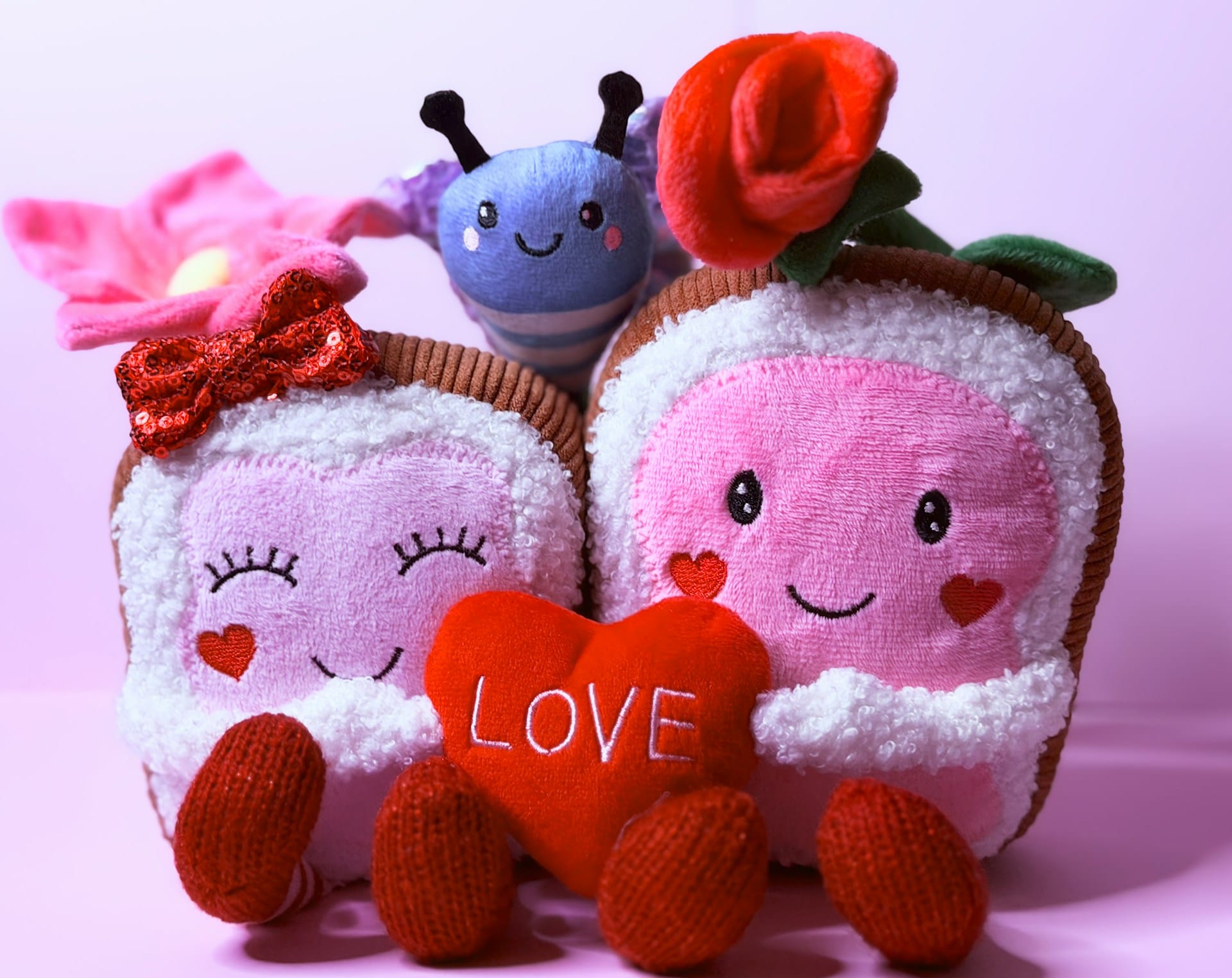 two plushies holding a heart sign