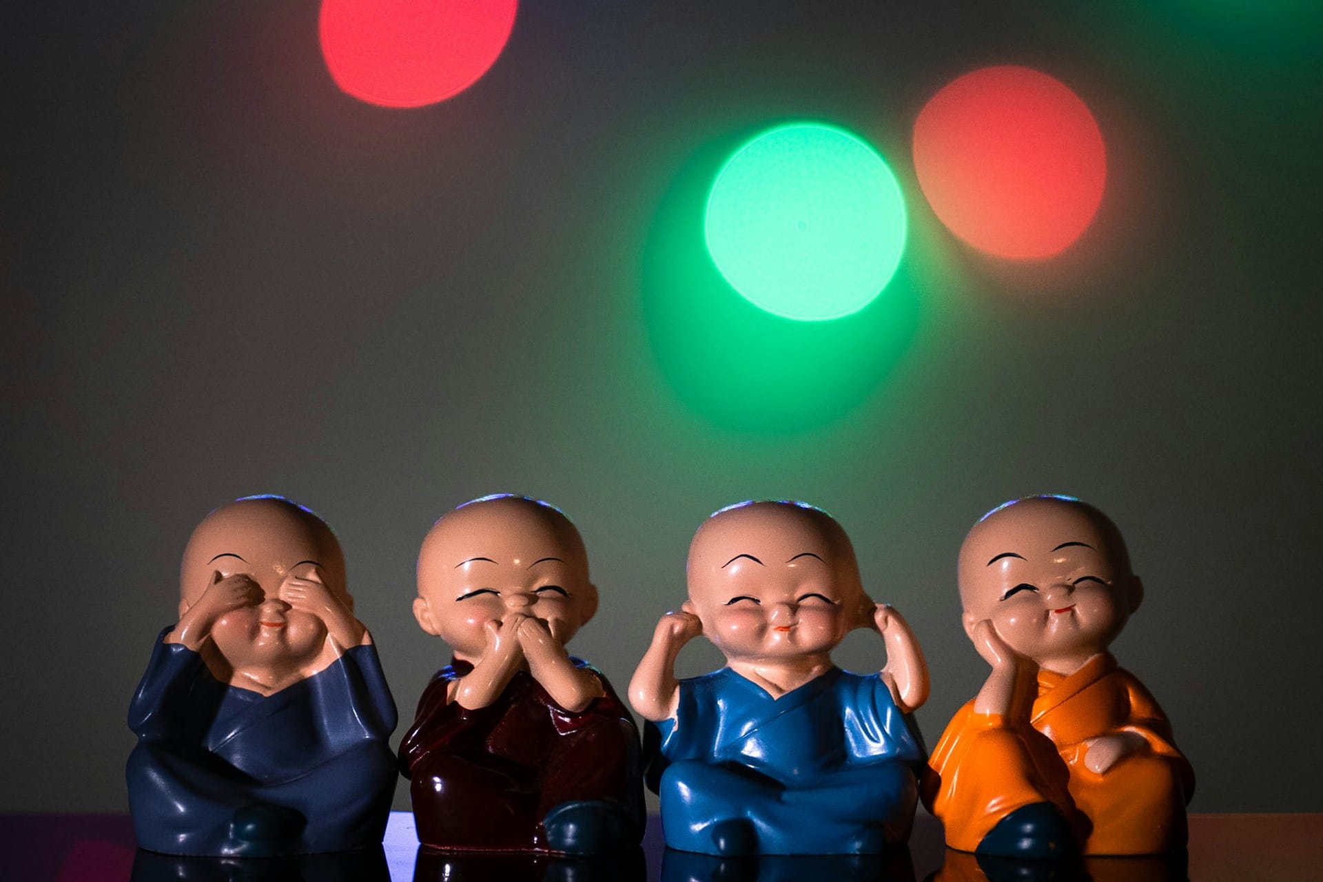 idols of four children with shaved heads depicting see no evil, speak no evil, hear no evil, and stay serene