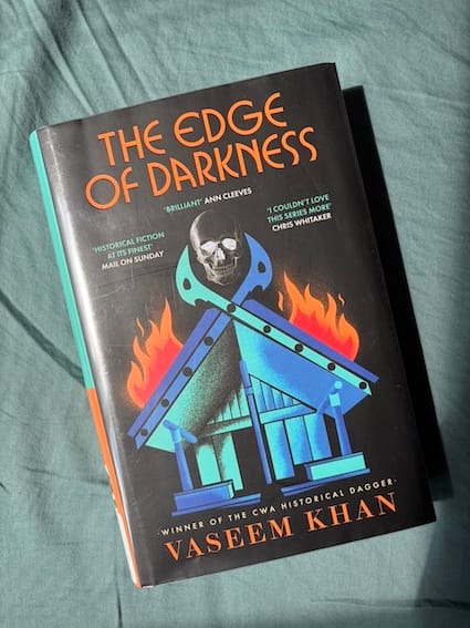 Hardback copy of The Edge Of Darkness by Vaseem Khan featuring a burning house