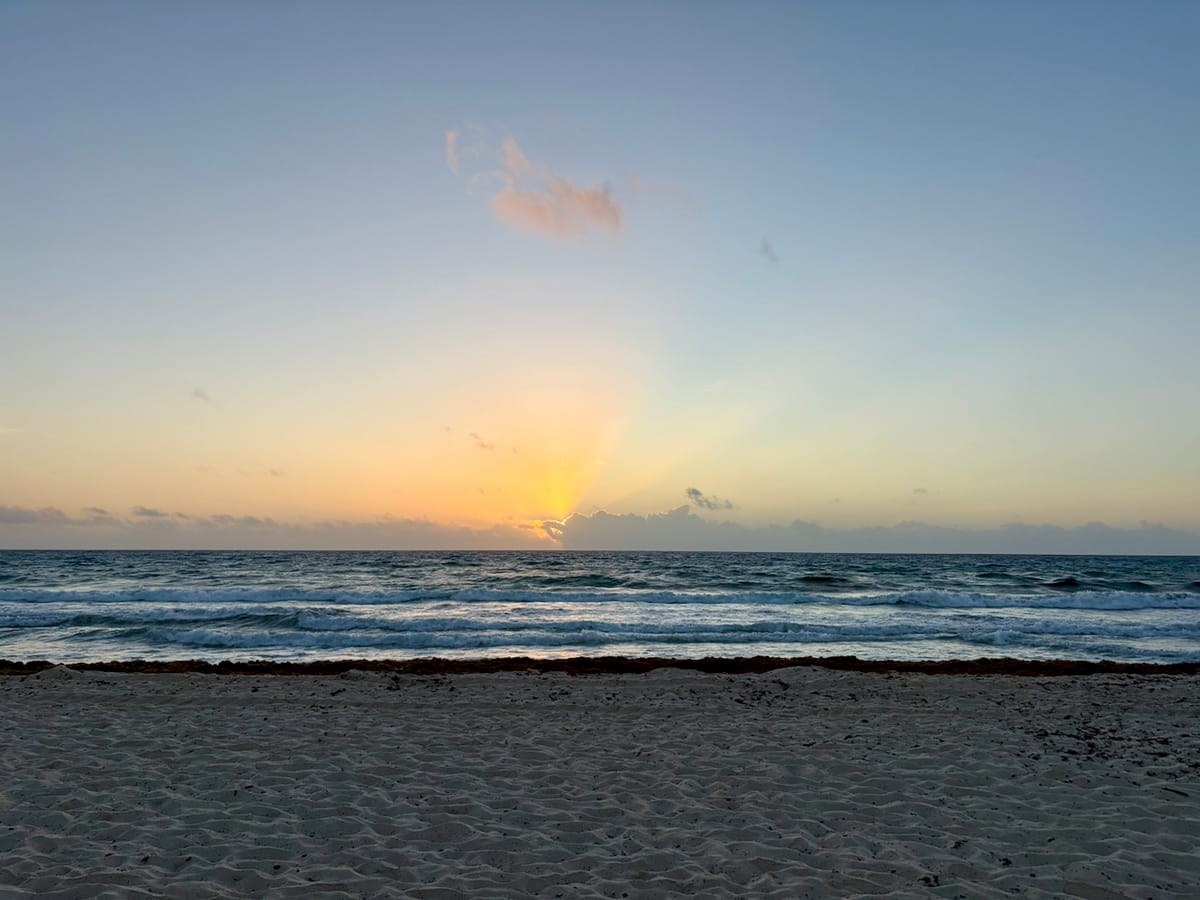 sunrise over an ocean as seen from the shore