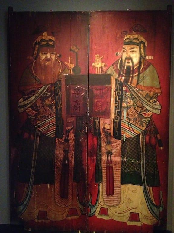 a red wooden double door with Chinese Gods painted on it
