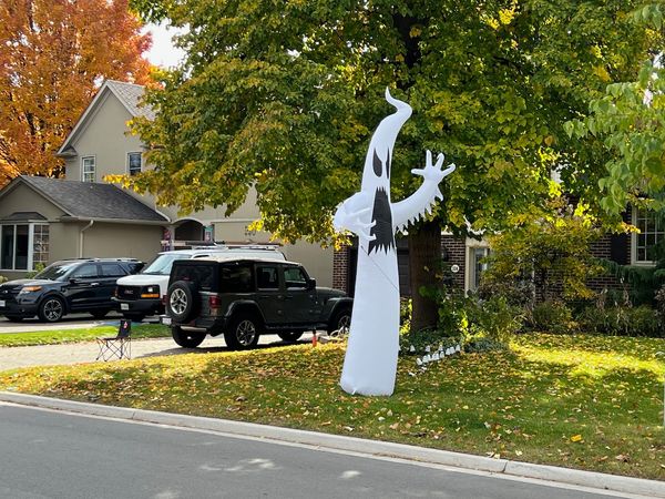 angry-looking ghost inflatable on a lawn set up for Halloween