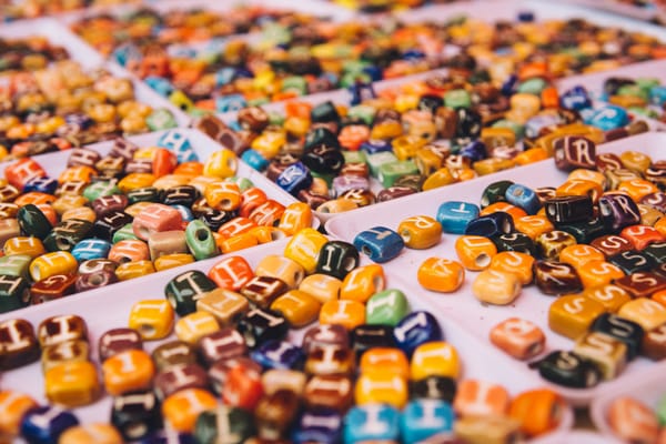 alphabet beads of assorted colours on a white tray