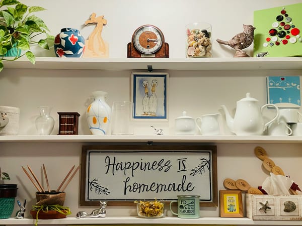 shelves with household items including a poster that says 'Happiness is homemade'