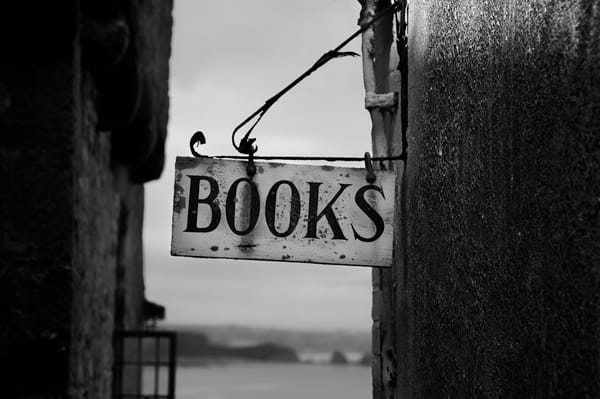 rectangular wooden board saying 'BOOKS' hung on the side of a wall