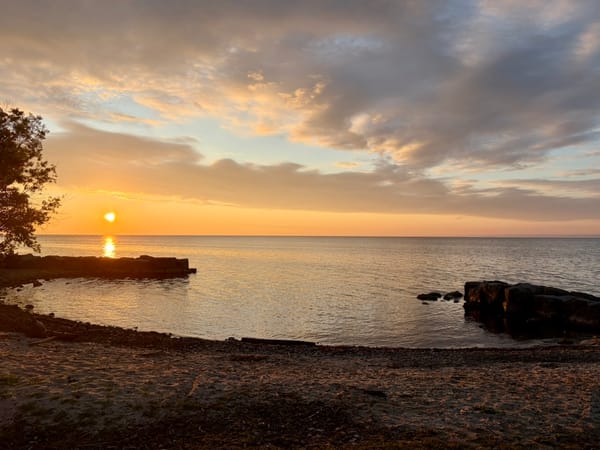 the sun rising over the shores of Lake Ontario