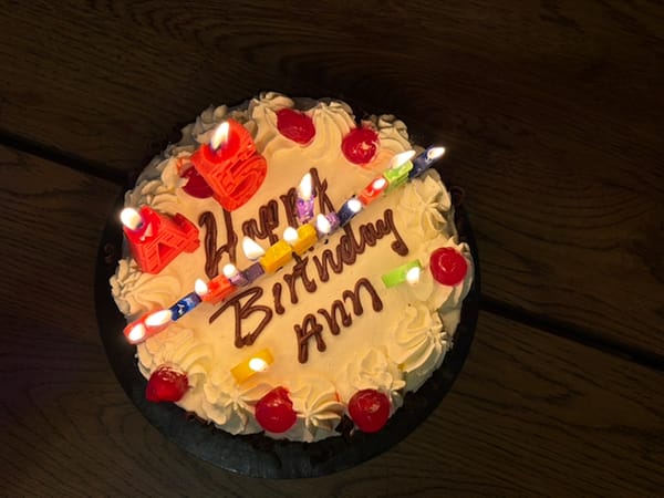 black forest birthday cake with candles, cherries and a 'Happy Birthday Ann' message