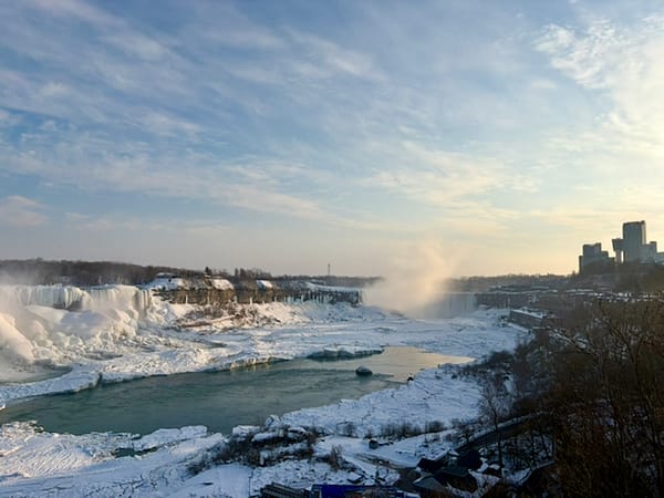 frozen Niagara Falls and River under a pale blue sky