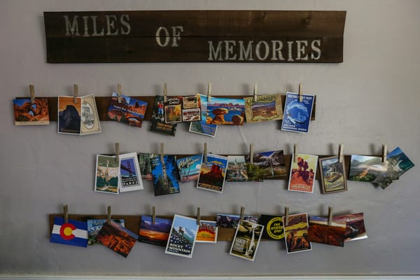 photos on a wall under a wooden plank with the words 'Miles Of Memories'