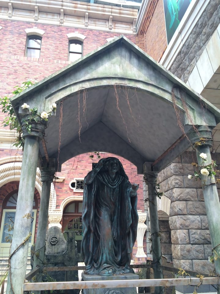 statue of a man in robes inside a square pavilion with four pillars on the corners