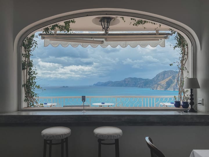 bay window overlooking a blue ocean and distant hills