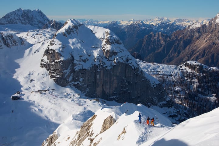 three mountaineers traversing snow-capped peaks