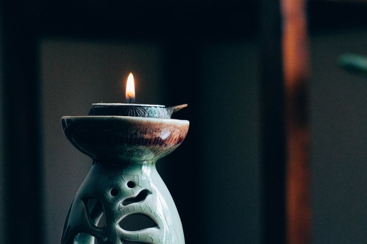 a lit oil lamp atop a lamp holder