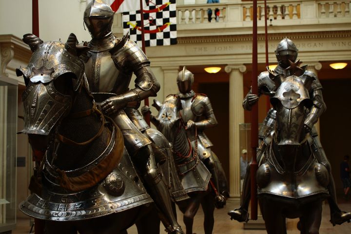 statues of three soldiers in metal suits on horseback