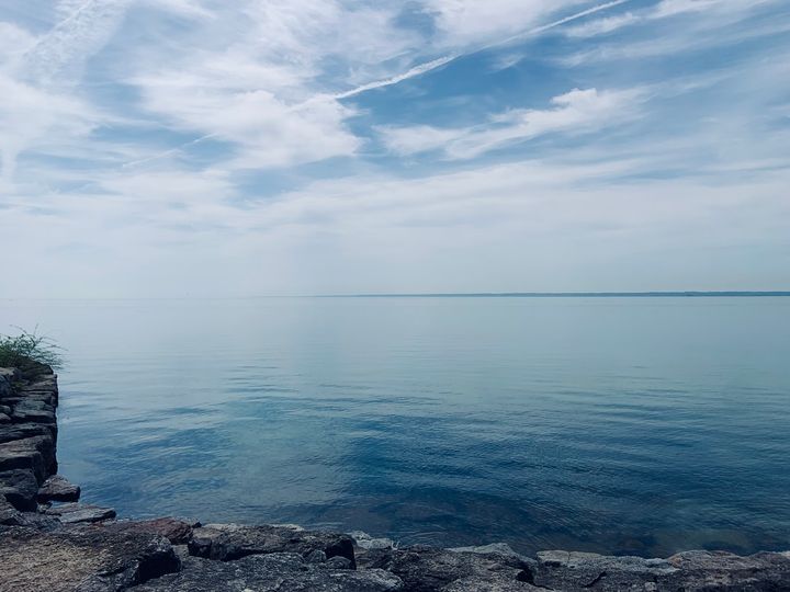 blue lake waters under a blue sky with white clouds