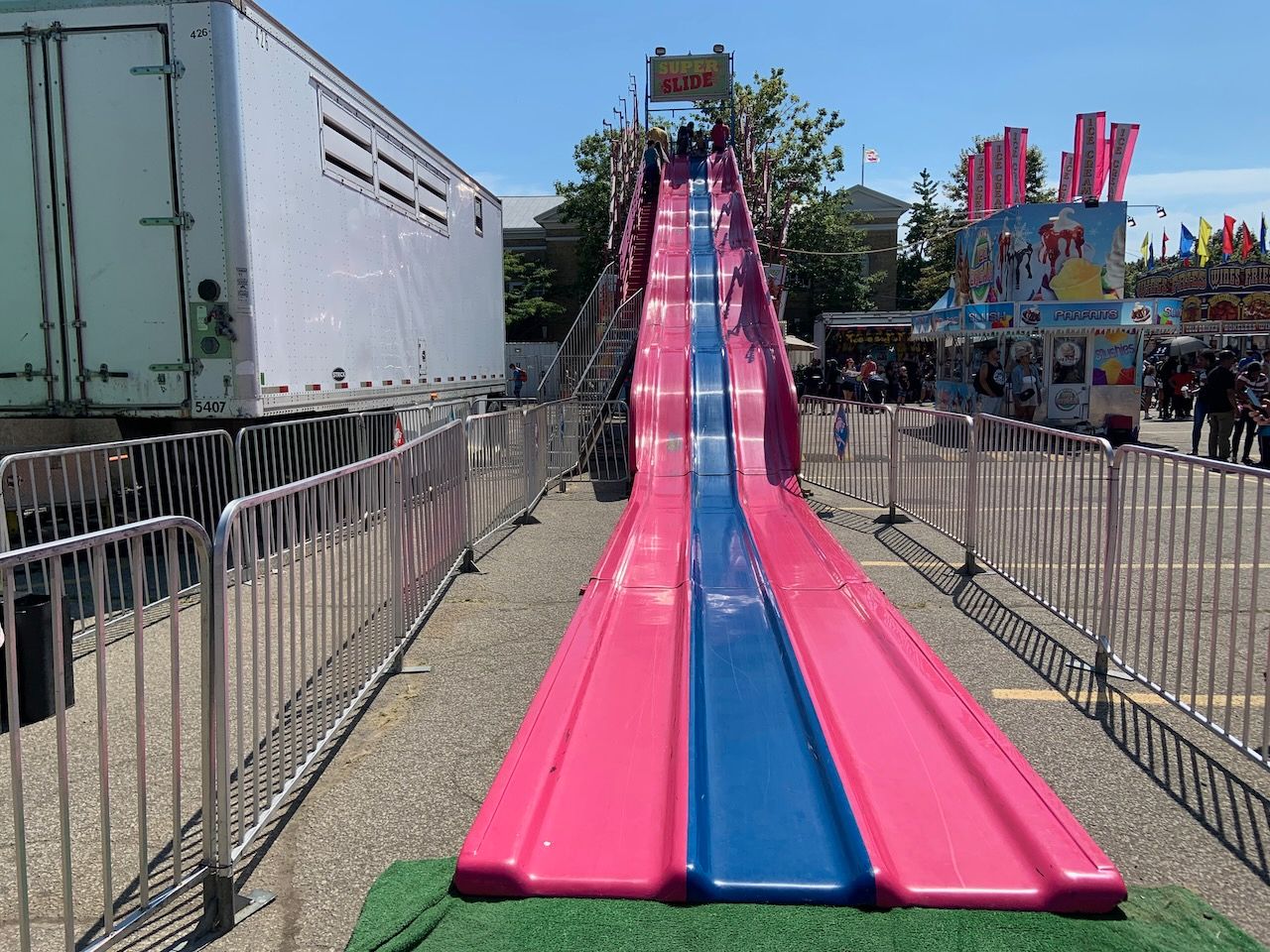 a super long slide with three adjacent lanes in pink and blue