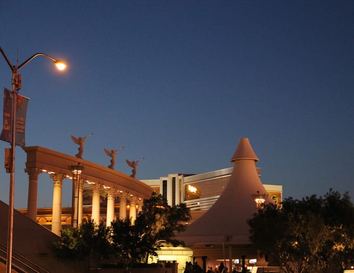 statues of three winged angels playing their horns atop a bridge against the night sky