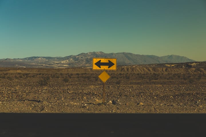 signboard with arrow pointing both ways in the middle of a desert