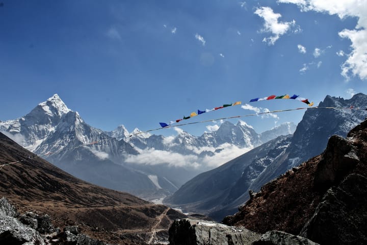 a string of pennants flying in the breeze against a backdrop of snow-capped mountains