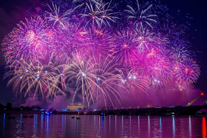 fireworks in the night sky over a waterfront city