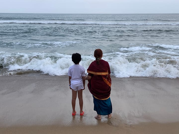 view of my mom and my child at the seashore waiting for the next wave to roll in