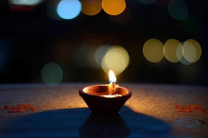 a clay lamp flickering against a dark background 