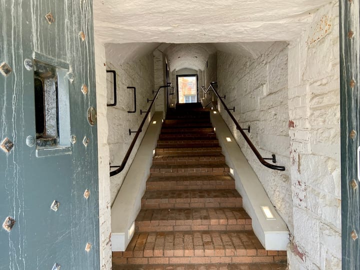 a flight of stairs framed by a doorway leading to another doorway at the top
