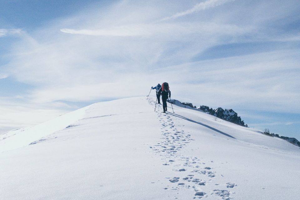 Two mountaineers climbing a snowy peak