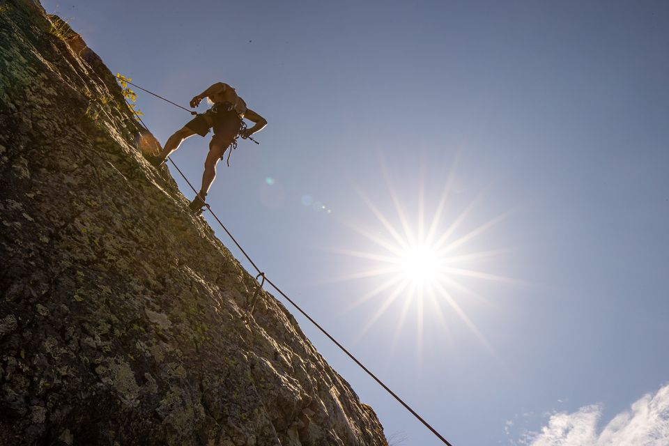 rock climber up on a hill slope with the sun beating down